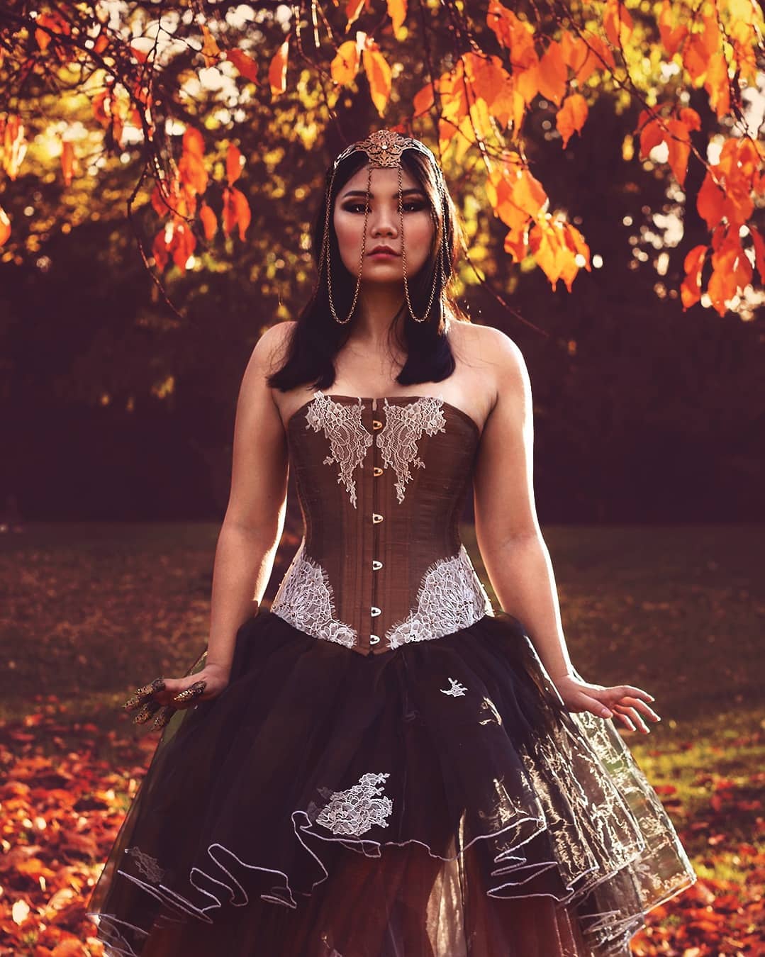 This stunning creation combines a luxurious shantung silk overbust corset with delicate white lace and brown rhinestone accents. The corset is expertly crafted, offering adjustable sizing with a front busk and lace-up back, reinforced with steel bones and lined with soft silk for both comfort and structure.
The showstopper is the voluminous skirt, made of three layers of delicate organza that flow with elegance and grace